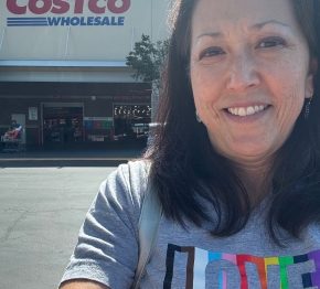Joyce wearing LOVE T-shirt in rainbow colors outside a Costco store