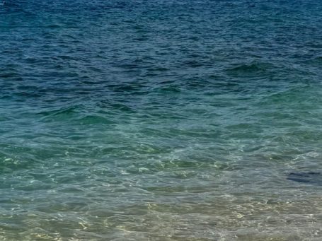 Ocean at shore moving from deep blue water to light blue water